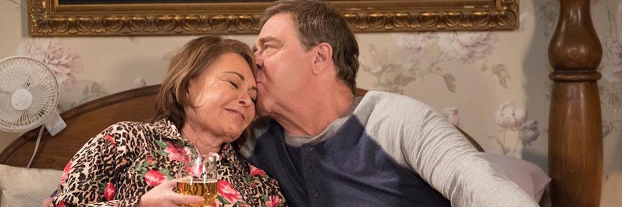 A picture of the two main "Roseanne" characters snuggling on their bed.