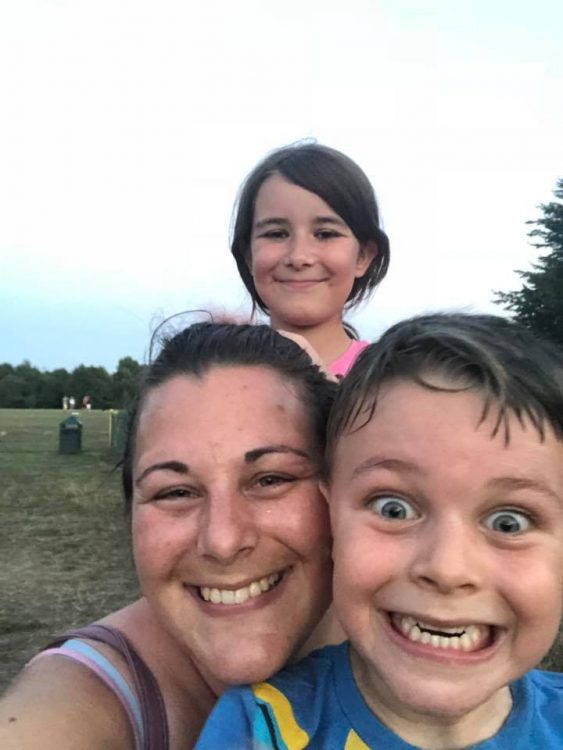 woman with two smiling young kids at park