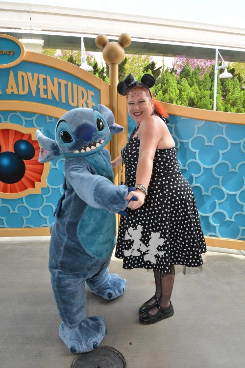 woman posing with Stitch at disneyland