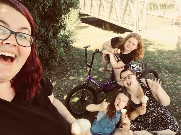 family sitting on grass with ice cream