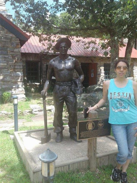 woman standing next to statue of outdoorsman