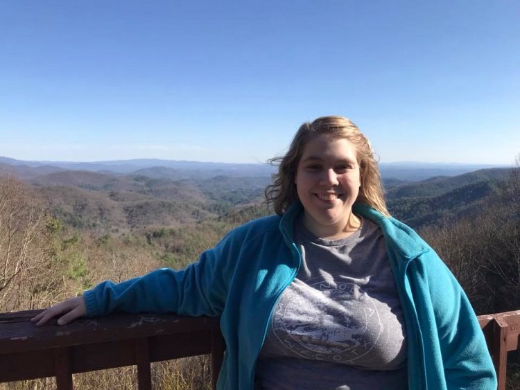 woman standing in front of scenic mountains