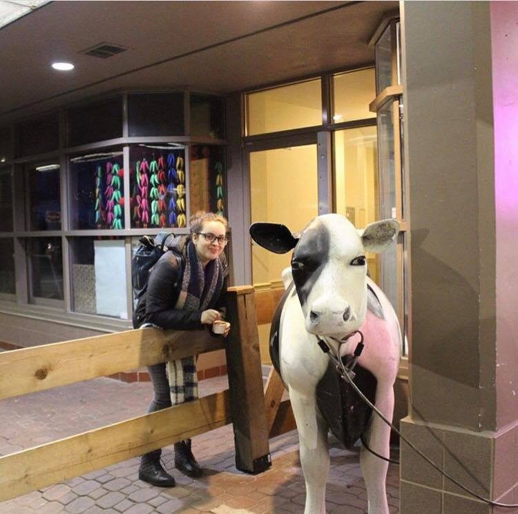 woman standing next to cow statue