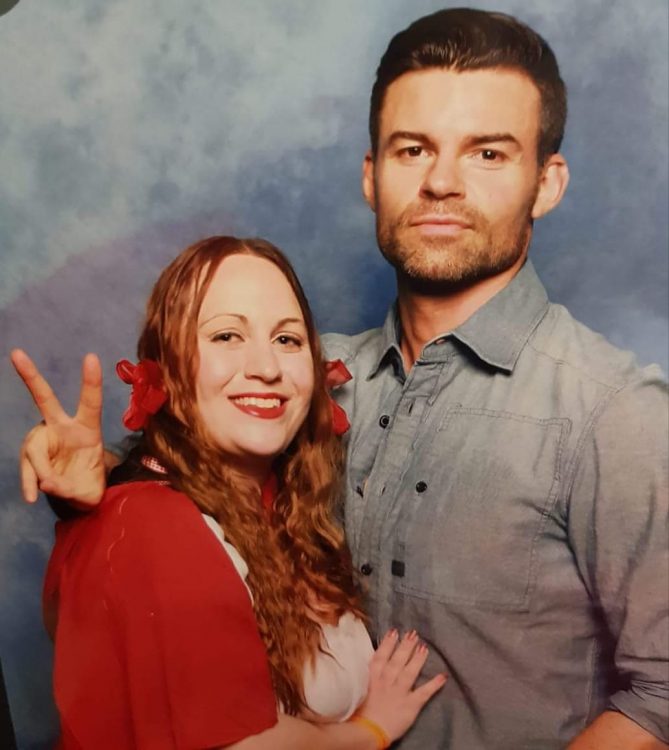 woman dressed as red riding hood standing with Daniel Gillies
