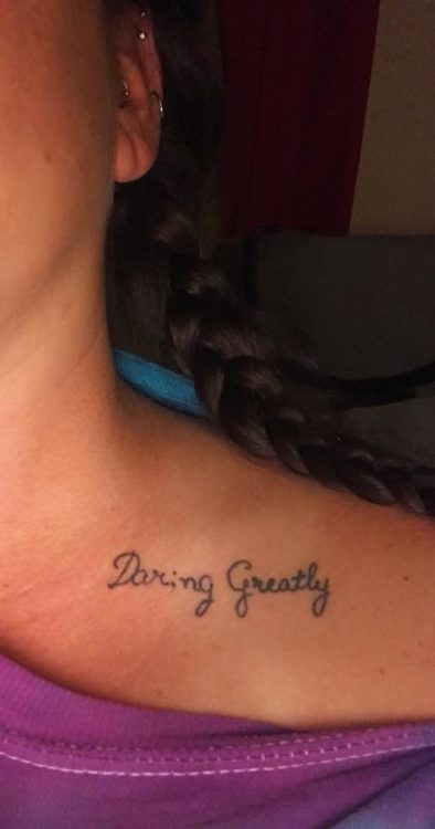 A tattoo on a shoulder that reads "Daring Greatly".