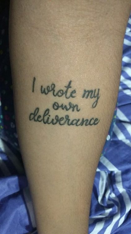 A tattoo reading: "I wrote my own deliverance."