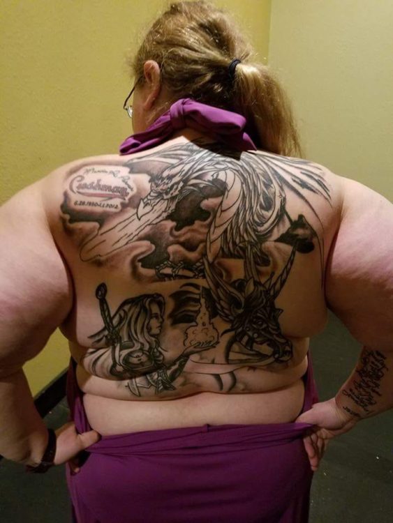 Full back tattoo of a knight, a horse, and a dragon.