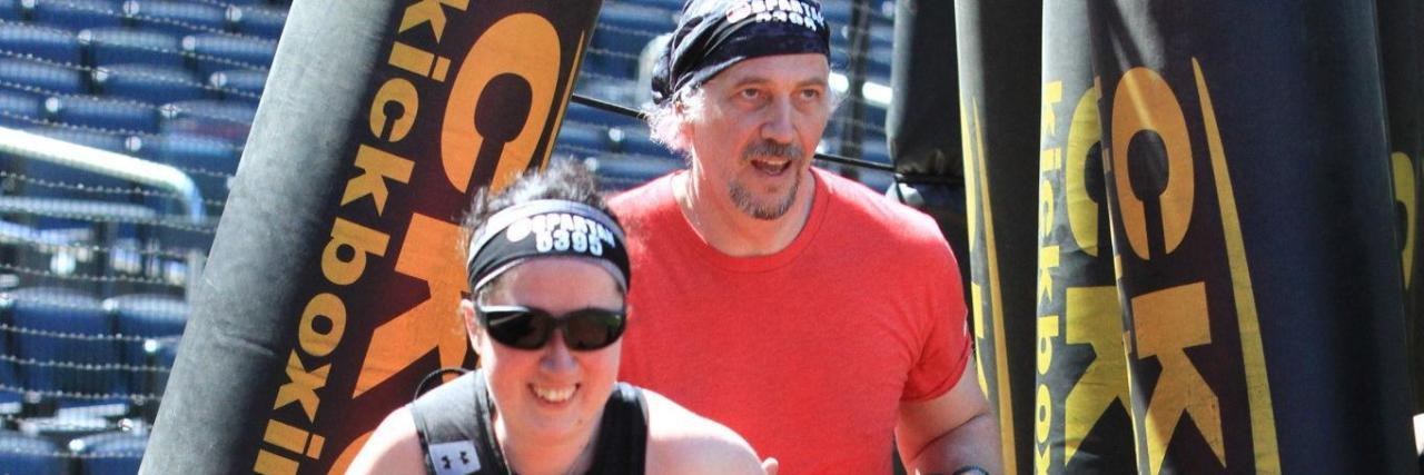 Breaking Through Limitations as a Blind Athlete Jess with her sighted guide in a Spartan race. She is running ahead of him.