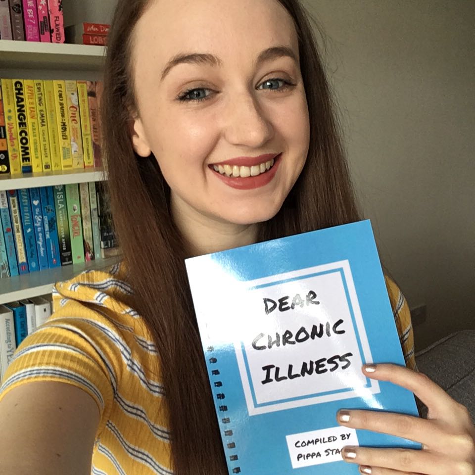 Pippa smiling and holding a copy of 'dear chronic illness' book