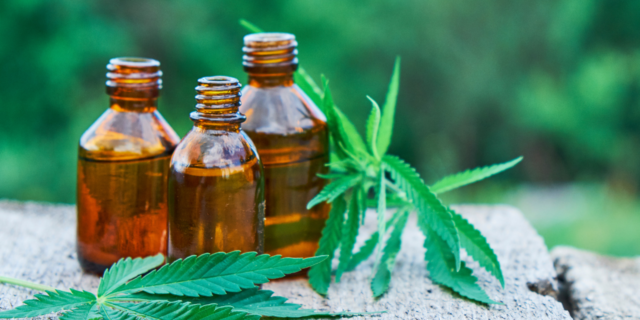 DEA Reclassified CBD-Based Drug, Epidiolex, to Show Lowest Risk for Abuse Three bottles of oil with marijuana leaves next to them.