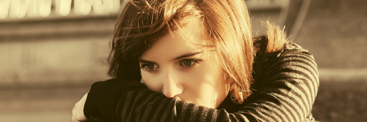 Losing a Loved One to Suicide a sad young woman with a red rose