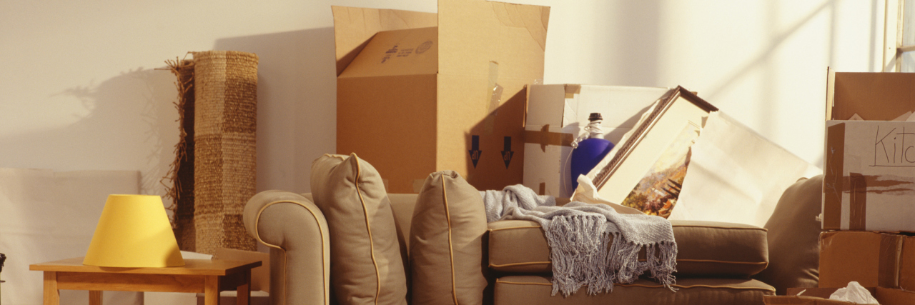 A pictures of unpacked boxes in a living room.