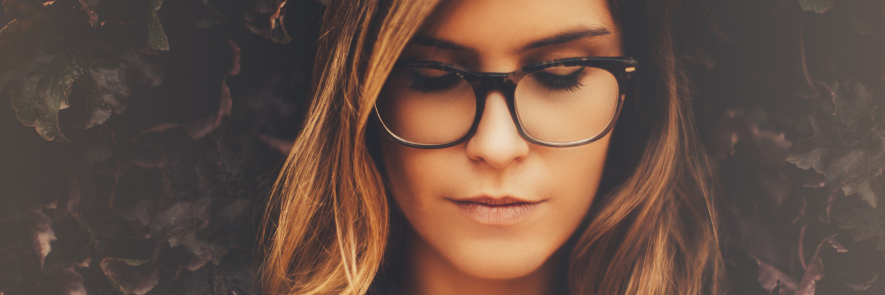 'Someday' Is No Longer My Illness Mantra A picture of a woman outside, looking down.