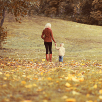 Happy family mother and child walking together in autumn park