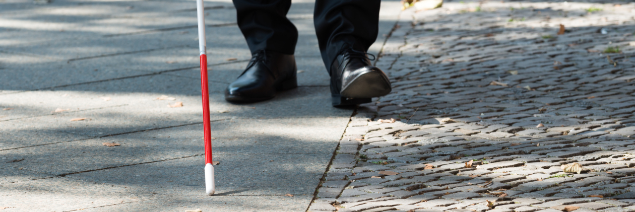 Facts About Blindness and White Cane Use Blind man walking with a white cane.