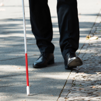 Blind man walking with a white cane.