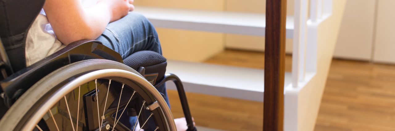 How Inaccessibility Leads to Social Isolation Person in a wheelchair in front of stairs.