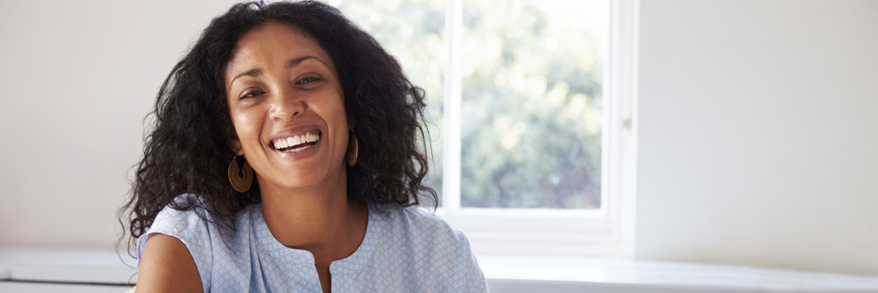 A woman sitting in a chair, smiling.