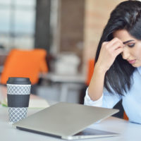 woman looking stressed over a computer