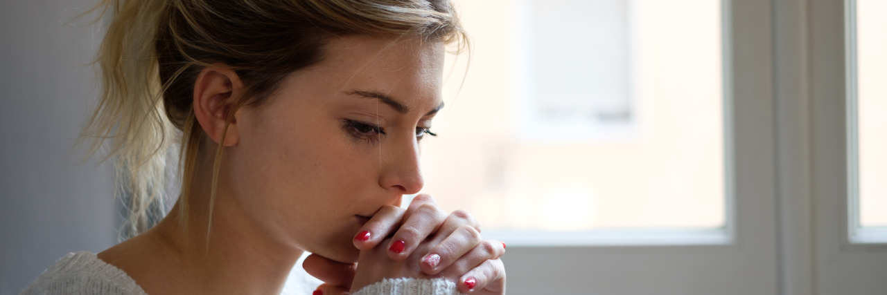 A picture of a worried woman, looking down.