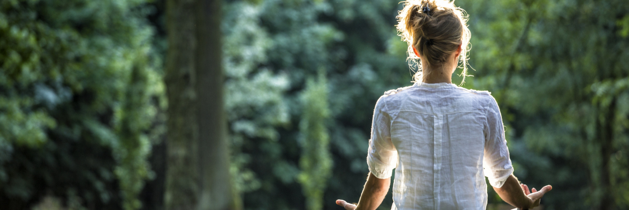 Self-Care for People on the Autism Spectrum Woman meditating in the park.