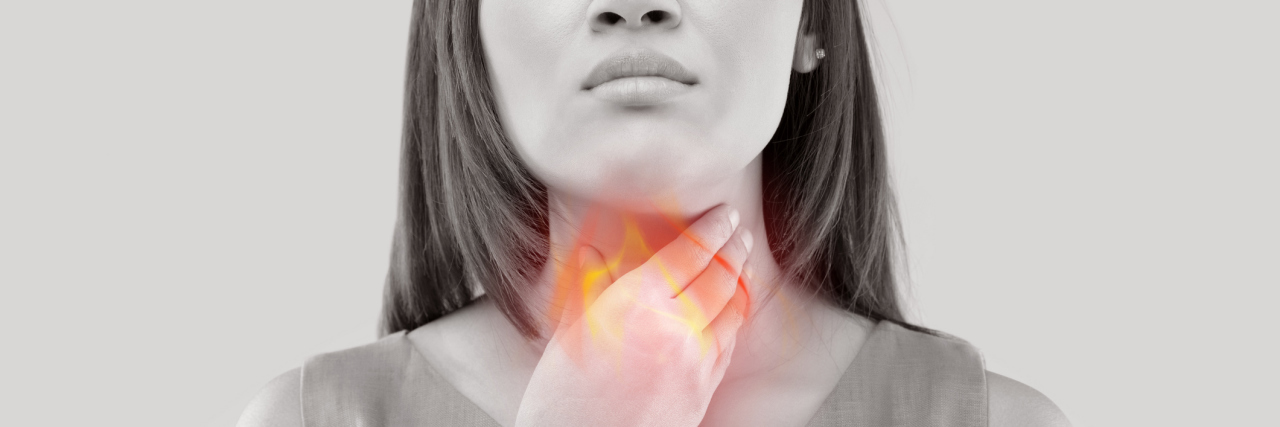 The Difference Between Heartburn, Acid Reflux and GERD black and white photo of a woman holding her throat with her esophagus lit up red