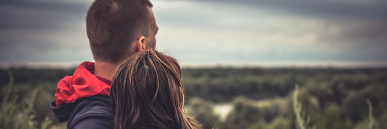 What Grief 'Looks' Like When Your Child Is Medically Complex Young couple embracing each other looking out in nature