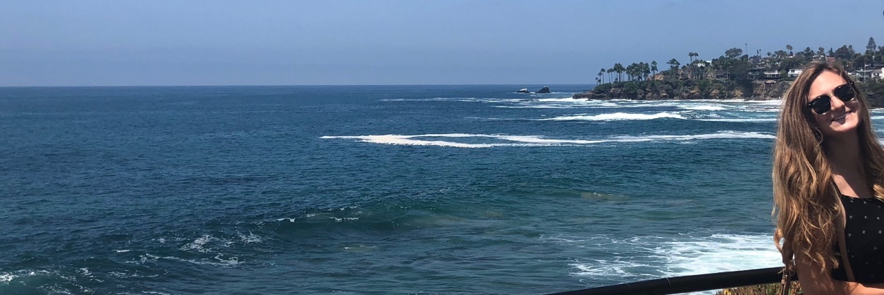 Experiencing a Lyme Disease Flare-Up After a Period of Good Health woman posing in front of the ocean