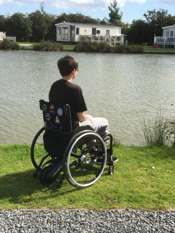 A person sitting in a wheelchair at a river.