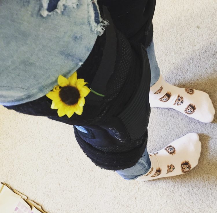 A woman wearing a knee brace with a sun flower