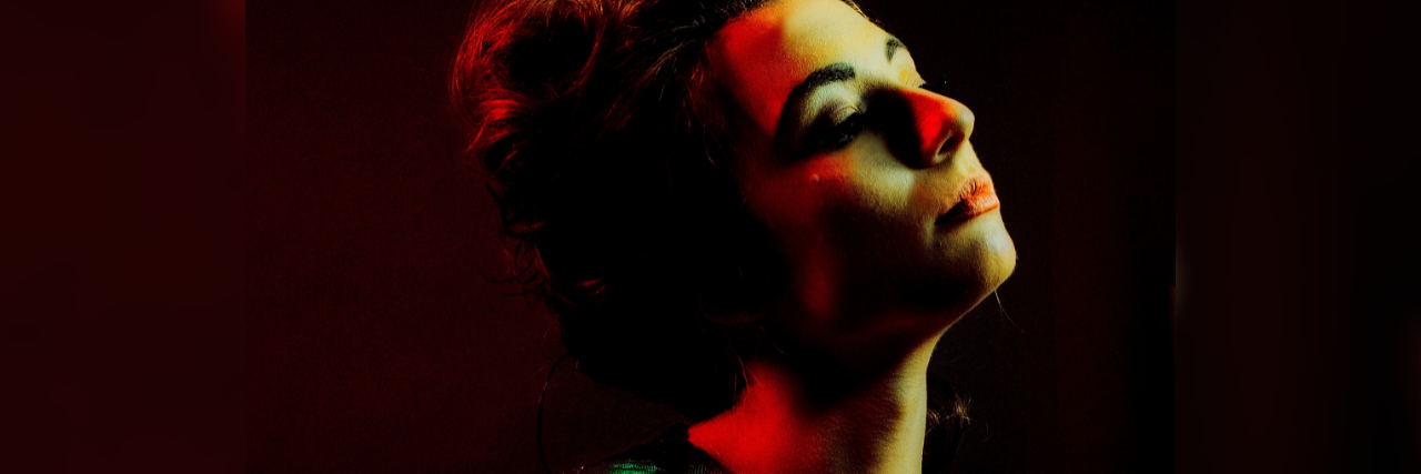 The Different Types of Pain I Experience With Fibromyalgia shadowy image of a woman wearing a green shirt and closing her eyes