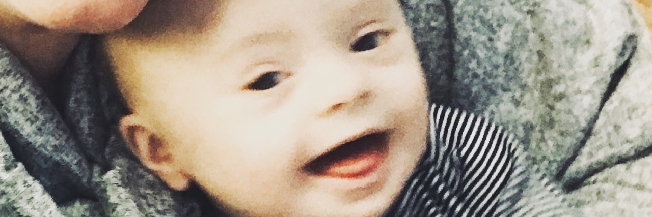 When My Son Was Given a Prenatal Diagnosis of Down Syndrome Selfie of mom smiling at camera with 6.5 month old baby with Down syndrome on her lap smiling at the camera, too.