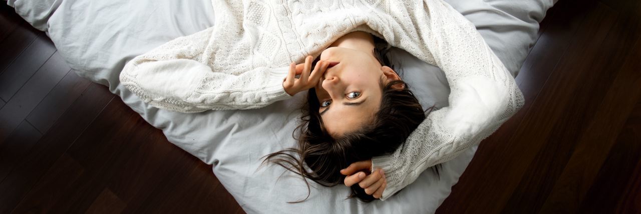 woman lying in bed looking up at camera