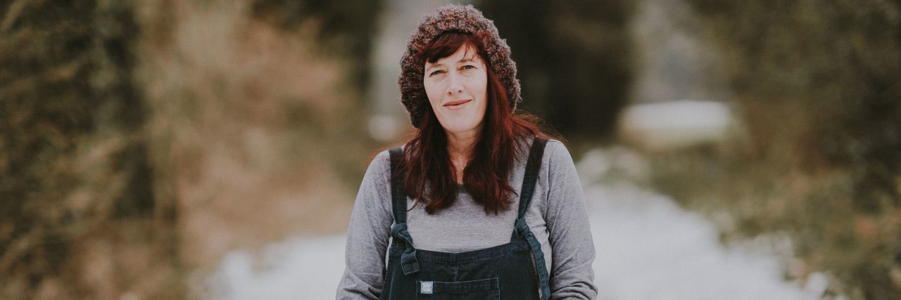 Can You Have Depression and Still Be Happy? Photo of redhead woman standing in snow with slight smile