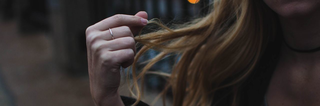 The Mental Illness I Can't Talk About muted photo of woman with long blonde hair running it through her fingers while seated on ground