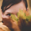 woman hiding behind leaf