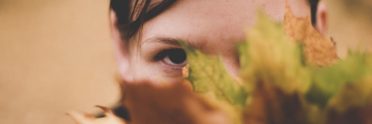 No, I Can't Just 'Push Through' My Social Anxiety woman hiding behind leaf