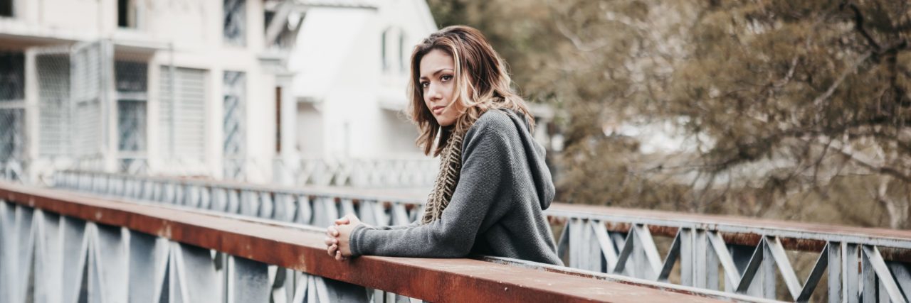 Advice for Depression and Anxiety Recovery young woman standing on bridge looking contemplative