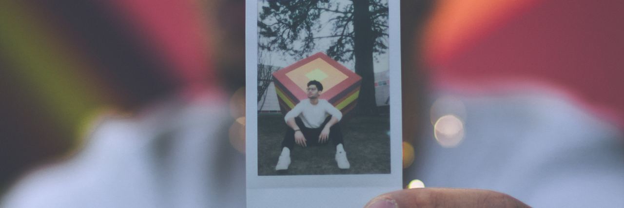 Unable to Find Help for Depersonalization Disorder man holding polaroid photo of himself in same place