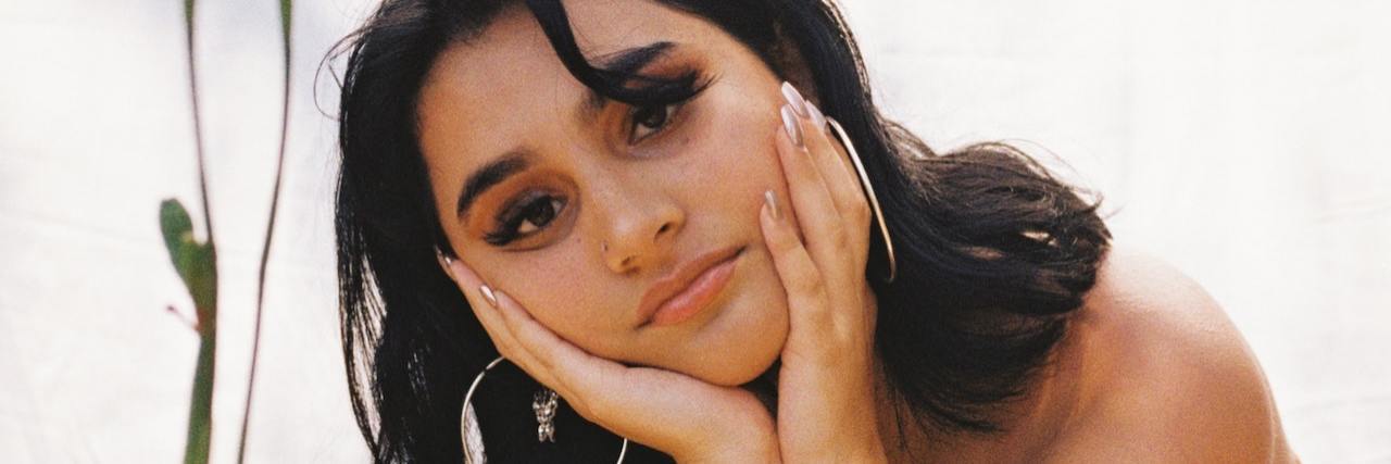 You Don't Always 'Recover' From Anxiety — and That's OK A woman tilting her head, resting it on her hands