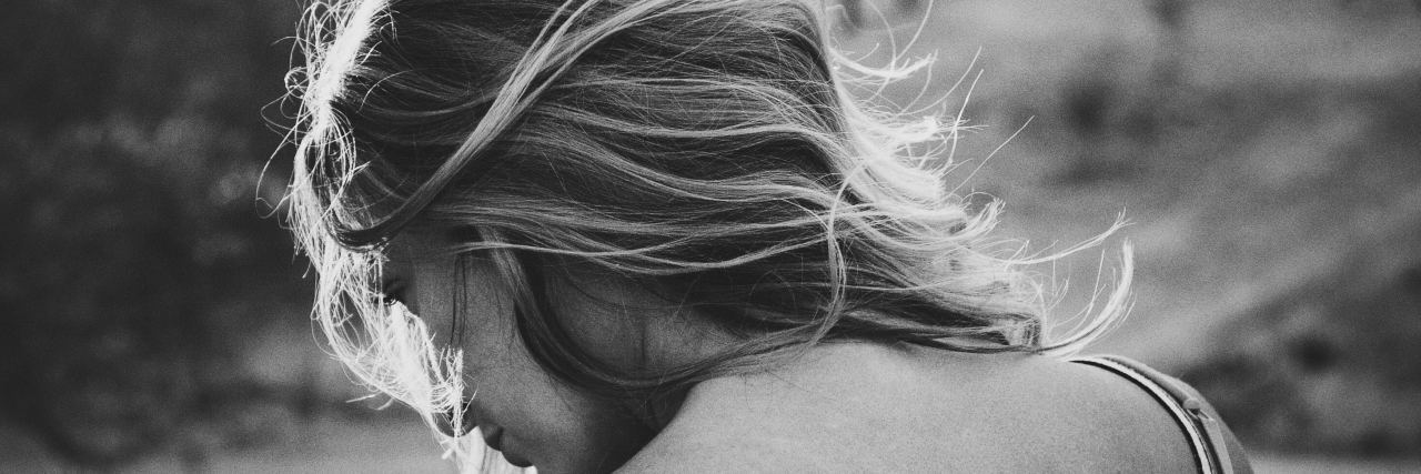What I Carry as an Endometriosis Warrior A black and white picture of a girl looking down.