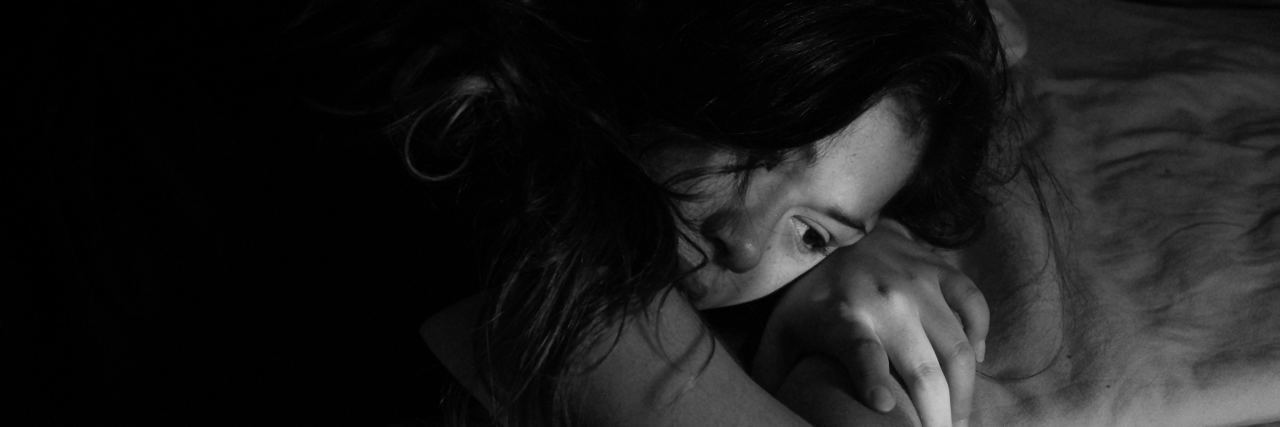 When Illness Makes Me Miss Out and I Can't Catch Up A woman laying in her bed, looking tired and possibly sad.