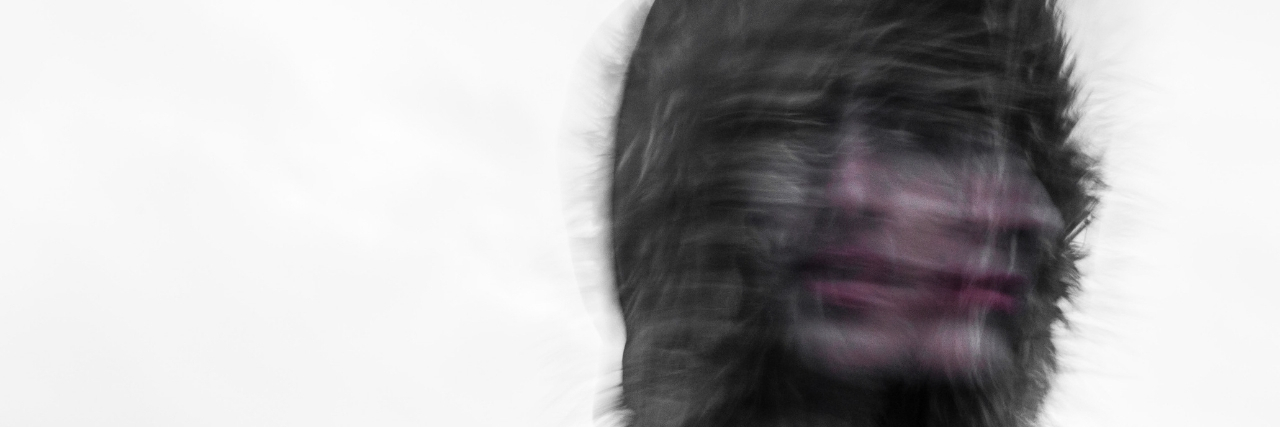 'Embarrassing' Symptoms of Panic Attacks We Don't Talk About A blurry photo of a woman