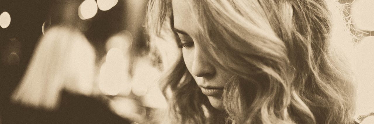 What Flashbacks Are Like for Someone With PTSD sepia photo of blonde woman looking down possibly upset