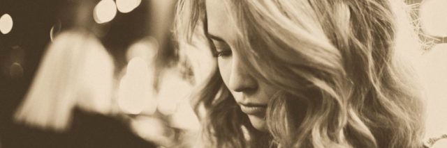 sepia photo of blonde woman looking down possibly upset