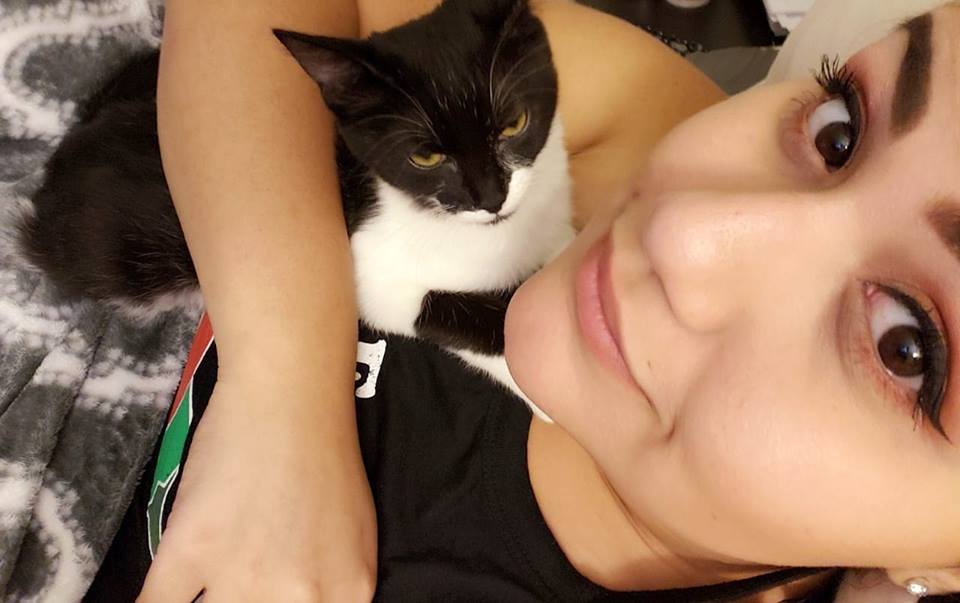 woman cuddling with a black and white cat