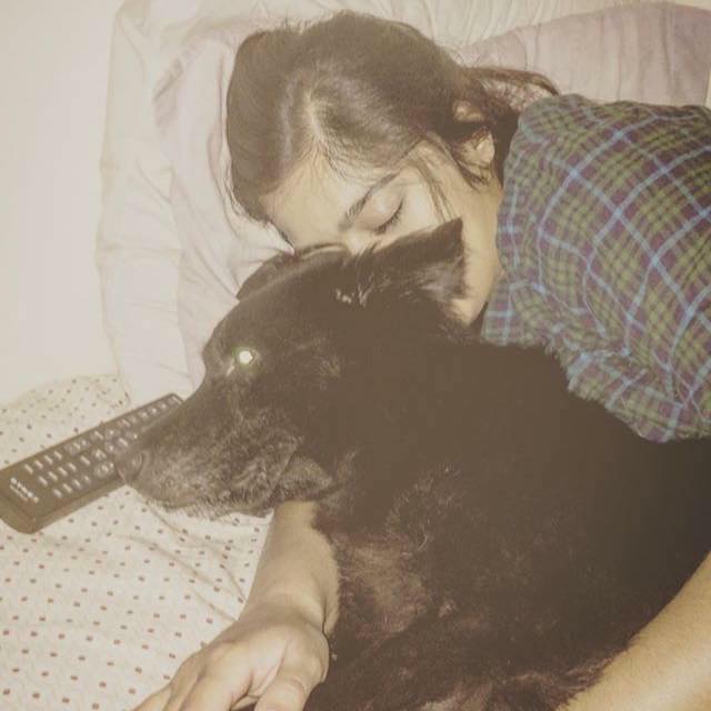 woman sleeping in bed next to her dog
