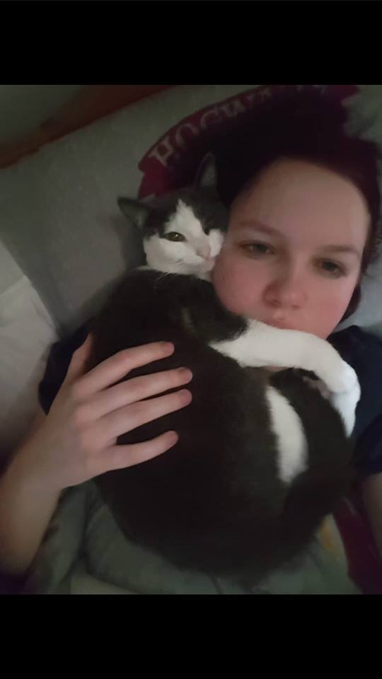 woman snuggling with her gray and white cat