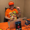 DJ Bob podcasting wearing an orange hat and Nickelodeon t-shirt.