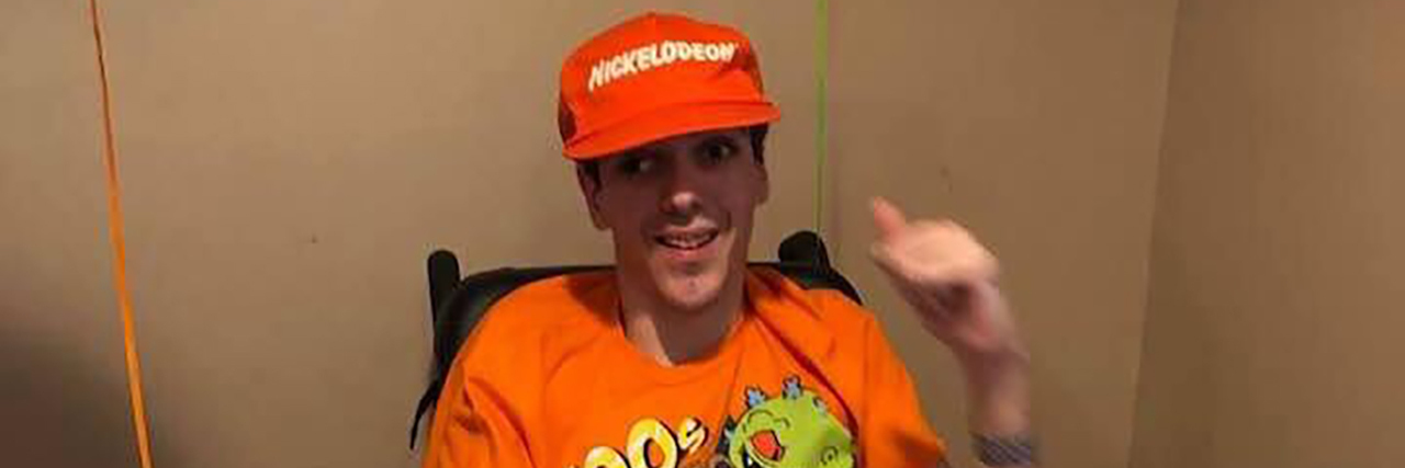 How Podcasting With a Disability Has Helped Me DJ Bob podcasting wearing an orange hat and Nickelodeon t-shirt.